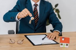 insurance-agent-holding-keys-with-house-model-and-2021-09-01-14-45-32-utc